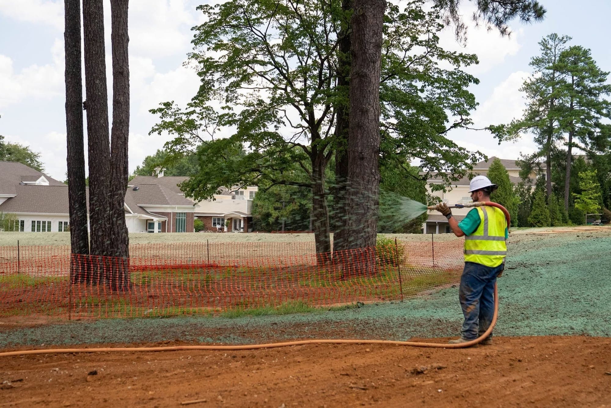 Prime Hydroseeding crew member hydroseeding a yard near an established residential neighborhood in Belmont, NC