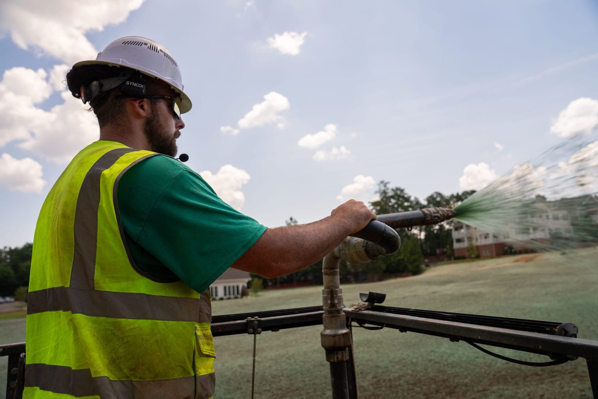 Prime Hydroseeding crew member applying hydroseed slurry from a commercial rig