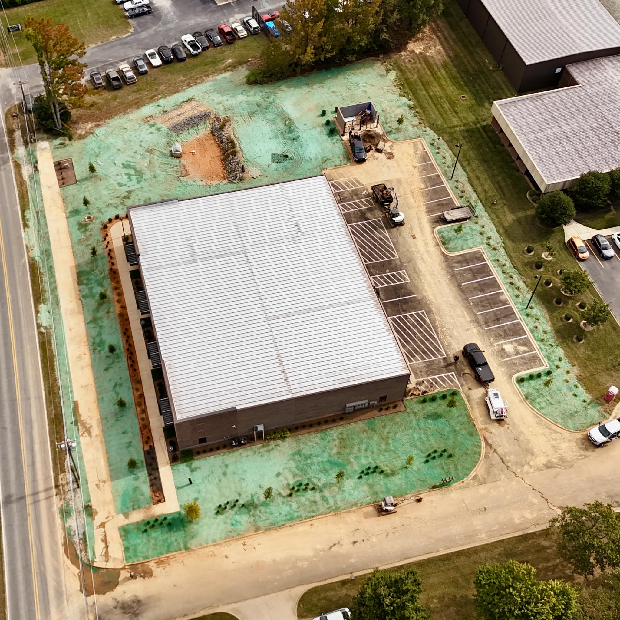 Aerial view of hydroseeded grounds and erosion control measures surrounding a large commercial construction site