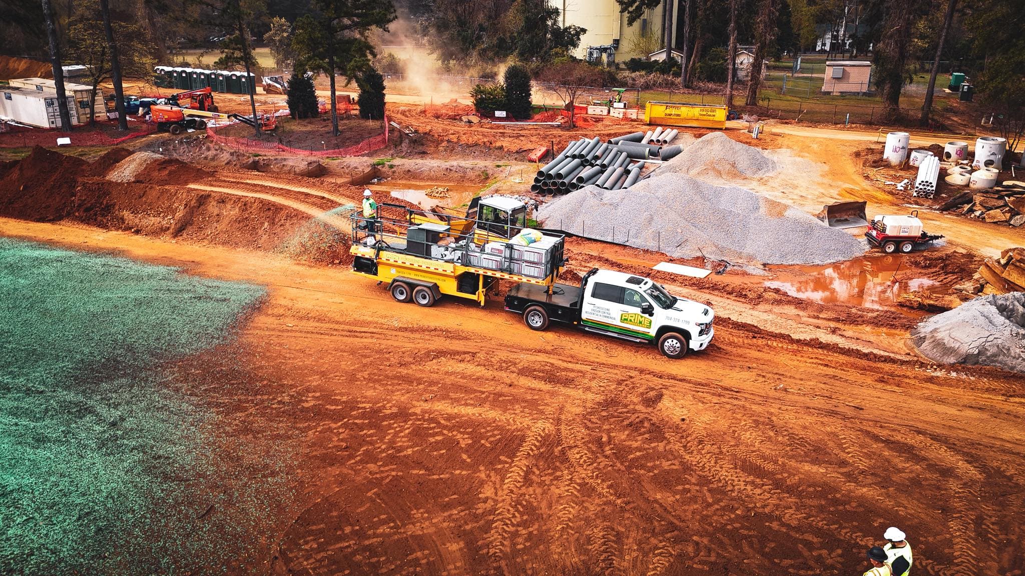 Aerial view of a Prime Hydroseeding truck and equipment applying hydroseed on a large commercial grading site