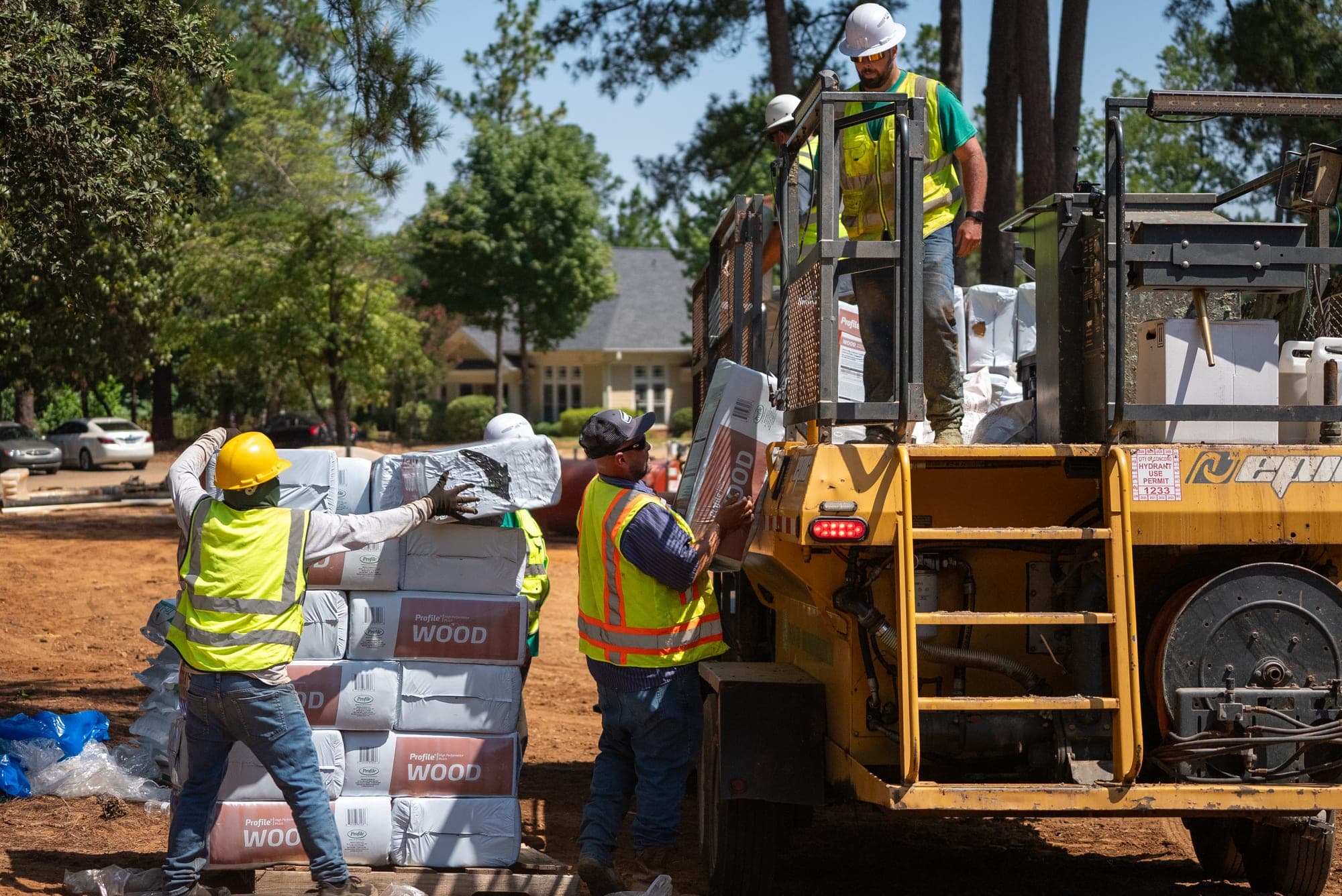 Prime Hydroseeding crew unloading hydraulic mulch material at a commercial construction site