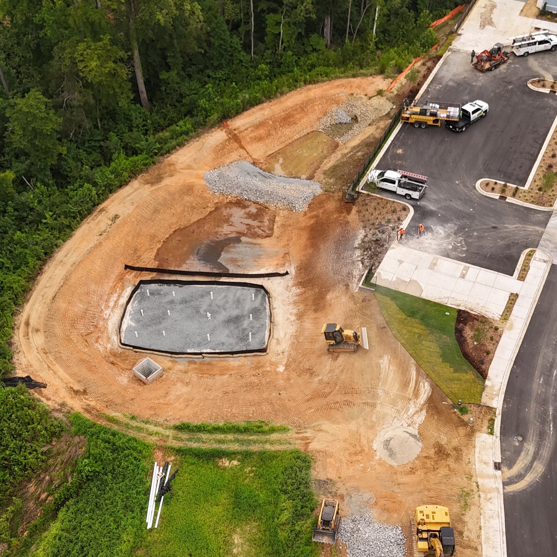Aerial view of a stormwater detention basin under construction being inspected before final acceptance