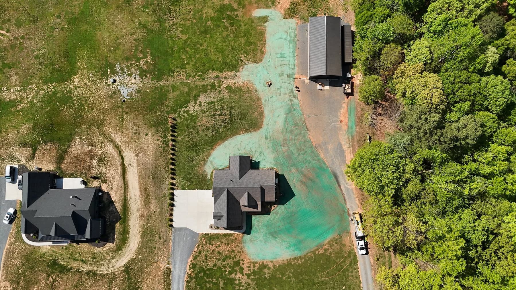 Aerial view of a freshly hydroseeded residential yard between two homes